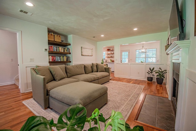 1682 Copperfield Cir, Tallahassee, FL 32312 - living room featuring wood finished floors, a fireplace with flush hearth, recessed lighting, and a chandelier