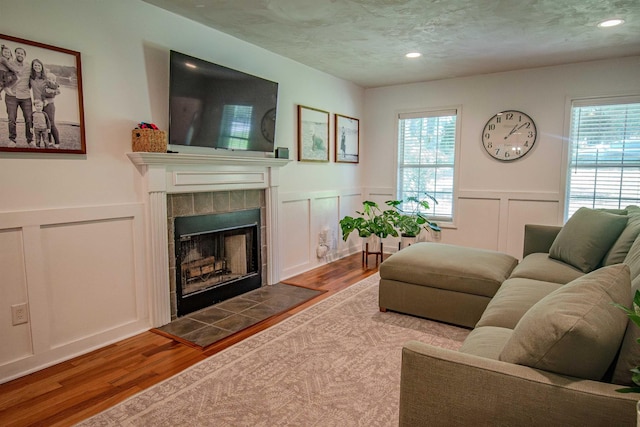 1682 Copperfield Cir, Tallahassee, FL 32312 - living area with a decorative wall, plenty of natural light, wood finished floors, a tile fireplace, and wainscoting