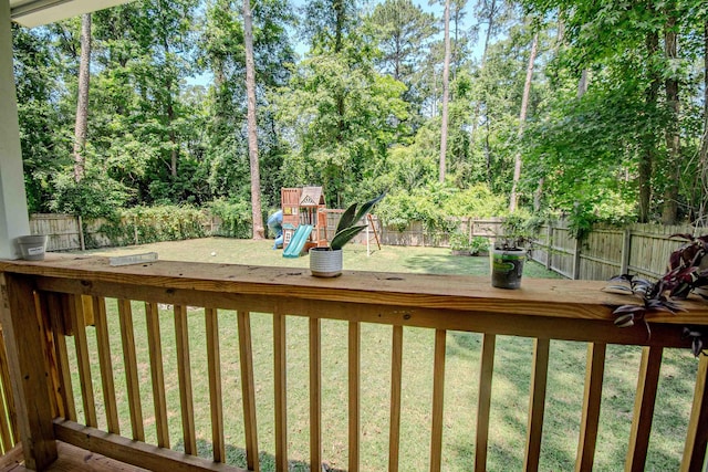 1682 Copperfield Cir, Tallahassee, FL 32312 - fenced backyard featuring a playground, a deck, and view of wooded area