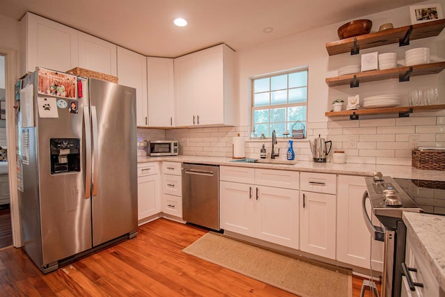 1682 Copperfield Cir, Tallahassee, FL 32312 - kitchen with stainless steel appliances, light wood-type flooring, decorative backsplash, white cabinetry, and recessed lighting