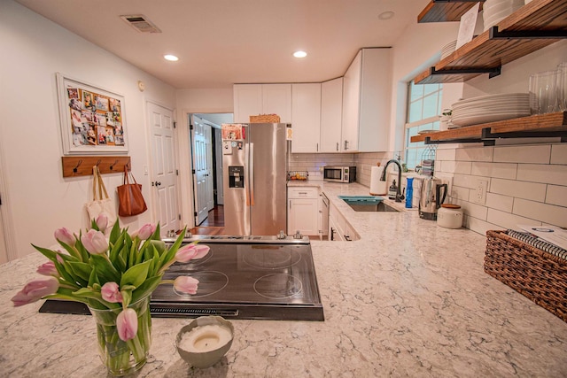 1682 Copperfield Cir, Tallahassee, FL 32312 - kitchen with appliances with stainless steel finishes, open shelves, decorative backsplash, light stone counters, and white cabinets