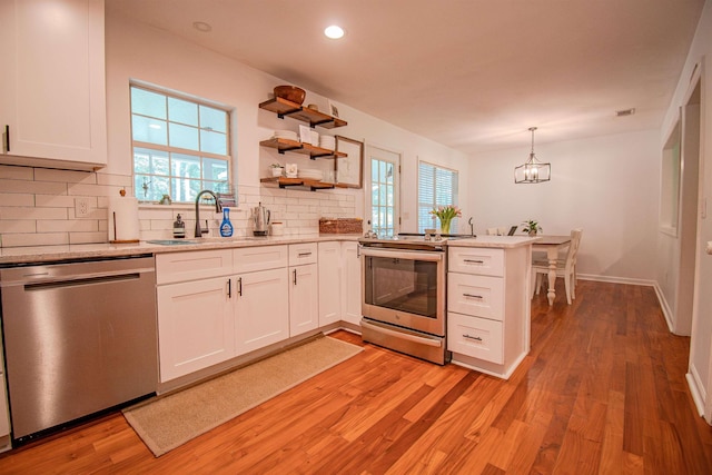 1682 Copperfield Cir, Tallahassee, FL 32312 - kitchen with appliances with stainless steel finishes, decorative backsplash, light wood-style floors, white cabinets, and recessed lighting