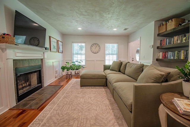 1682 Copperfield Cir, Tallahassee, FL 32312 - living room with wood finished floors, a tiled fireplace, wainscoting, and recessed lighting