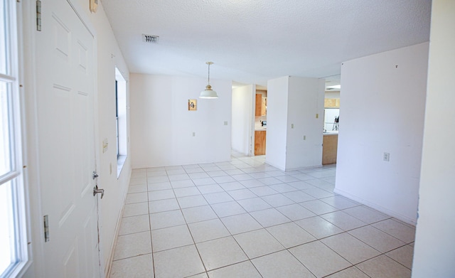 tiled spare room with a textured ceiling