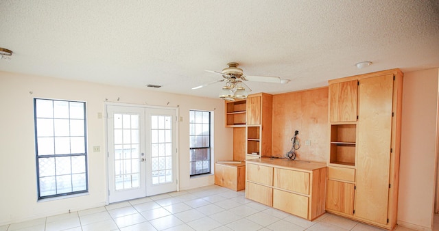 kitchen with ceiling fan, french doors, a textured ceiling, and light tile patterned floors