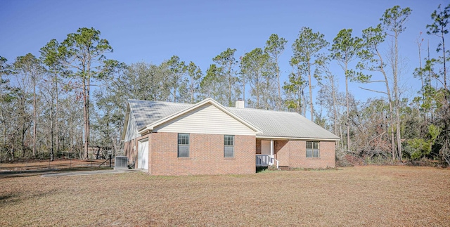 exterior space with a garage, a yard, and central AC unit