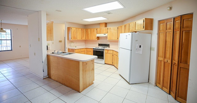 kitchen featuring white appliances, kitchen peninsula, light brown cabinetry, and sink