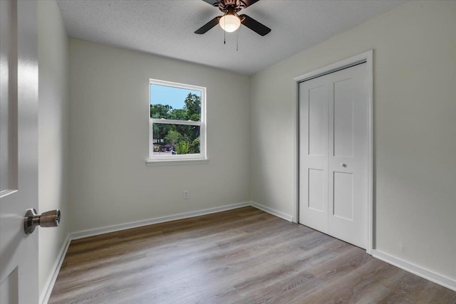 5400 Debbie Dr, Tallahassee, FL 32310 - unfurnished bedroom with wood finished floors, a closet, baseboards, a textured ceiling, and ceiling fan