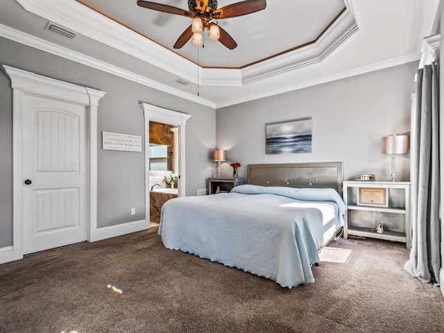 bedroom featuring visible vents, dark colored carpet, a tray ceiling, and ornamental molding