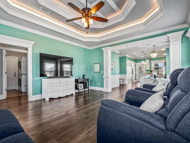 living room with visible vents, dark wood-style flooring, decorative columns, and stacked washer / drying machine