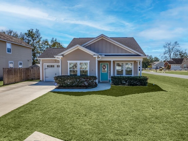 view of front of house with an attached garage, board and batten siding, fence, driveway, and a front lawn