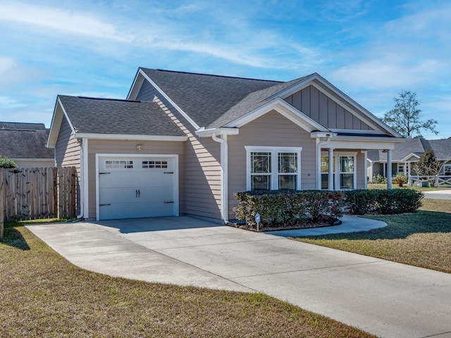 view of front of property with a garage, driveway, fence, a front lawn, and board and batten siding