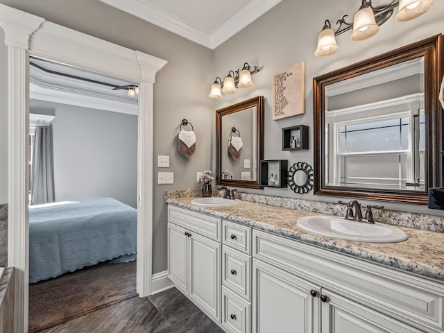 ensuite bathroom with double vanity, ensuite bath, crown molding, and a sink