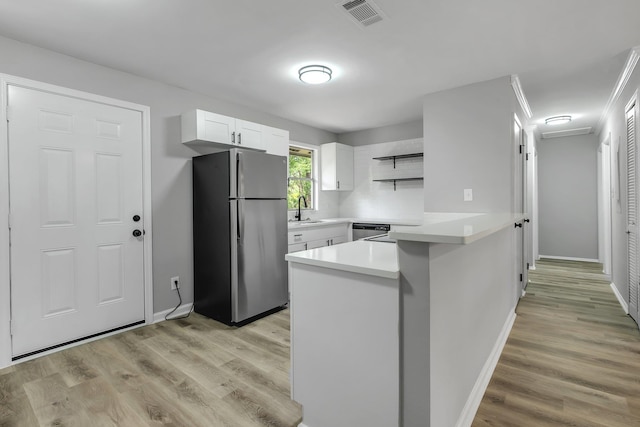 2212 Berkshire Dr, Tallahassee, FL 32304 - kitchen featuring visible vents, open shelves, a sink, freestanding refrigerator, and a peninsula