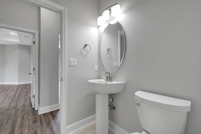 bathroom featuring hardwood / wood-style flooring and toilet