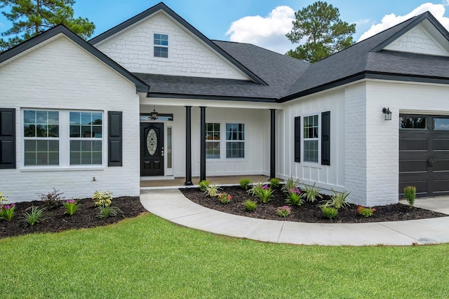 view of front of house featuring a porch, a garage, and a front lawn