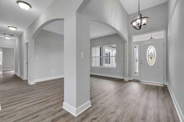 foyer featuring dark wood-type flooring and a notable chandelier