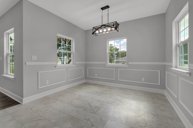 unfurnished dining area featuring an inviting chandelier