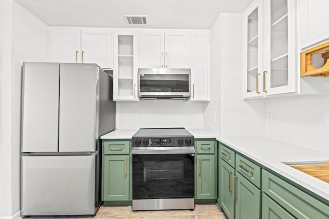 3142 Seattle Slew Ct, Tallahassee, FL 32309 - kitchen featuring green cabinetry, freestanding refrigerator, stainless steel microwave, electric range oven, and white cabinets