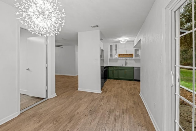 3142 Seattle Slew Ct, Tallahassee, FL 32309 - kitchen with green cabinets, dishwasher, a sink, light wood-style floors, and freestanding refrigerator