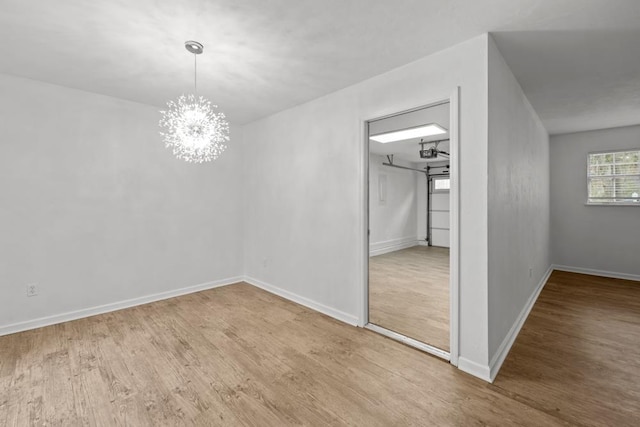 3142 Seattle Slew Ct, Tallahassee, FL 32309 - unfurnished bedroom featuring wood finished floors, a chandelier, and baseboards