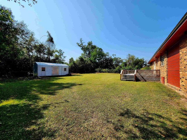 view of yard with a wooden deck and a storage shed