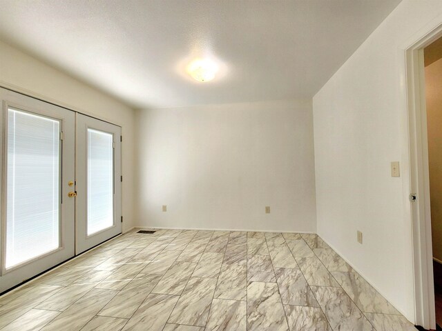 unfurnished room featuring french doors