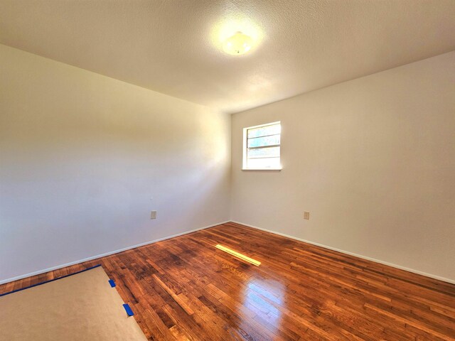 spare room with wood-type flooring and a textured ceiling