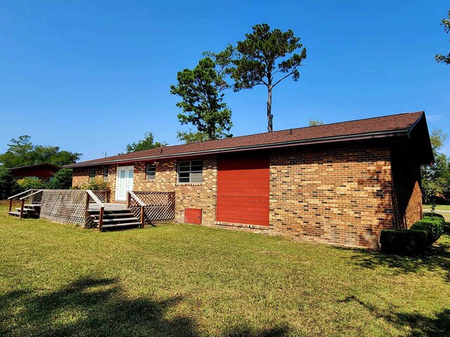 back of house with a lawn and a deck