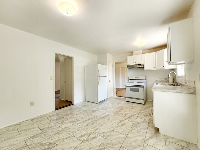 kitchen with white appliances, white cabinetry, and sink