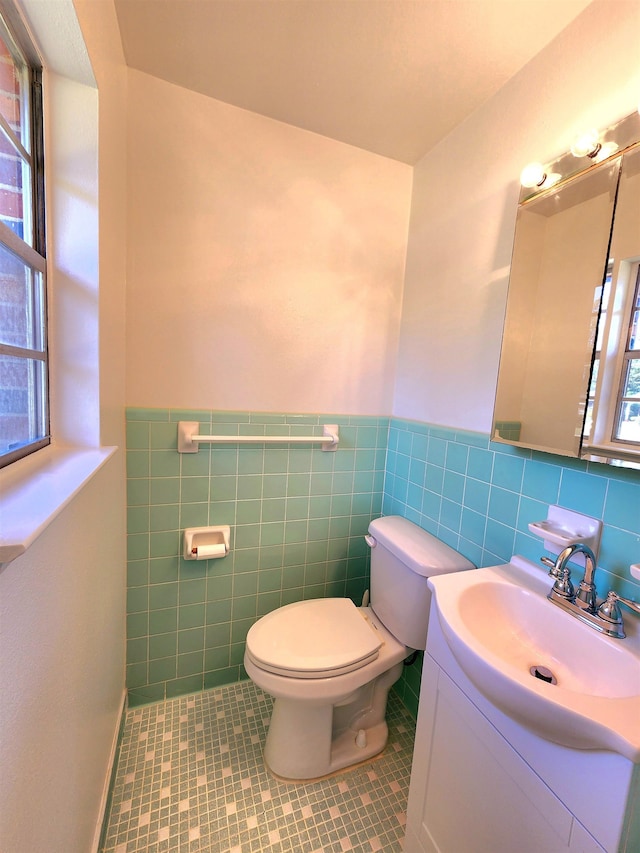 bathroom featuring vanity, tile patterned flooring, toilet, and tile walls