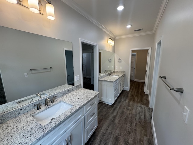 full bath featuring ornamental molding, two vanities, a sink, and visible vents