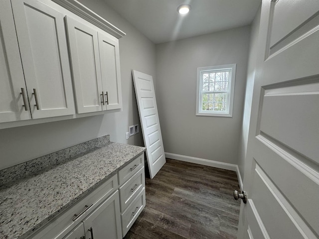 washroom with dark wood-style flooring and baseboards