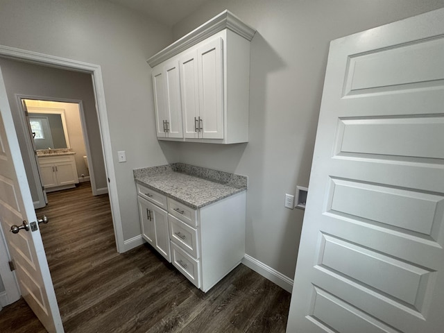 laundry area with baseboards and dark wood finished floors