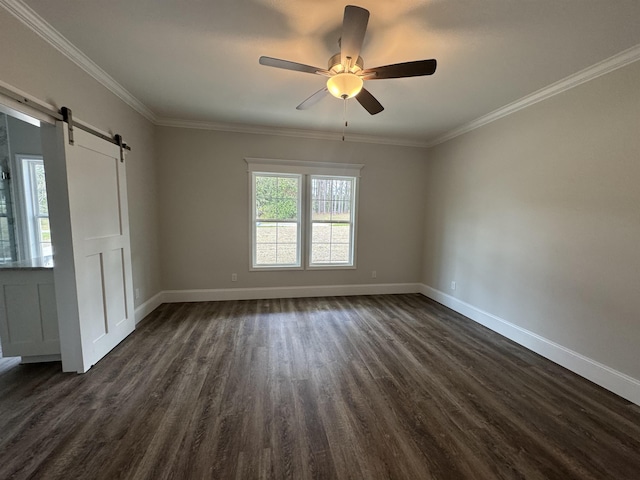 spare room with a barn door, crown molding, baseboards, and dark wood-style flooring