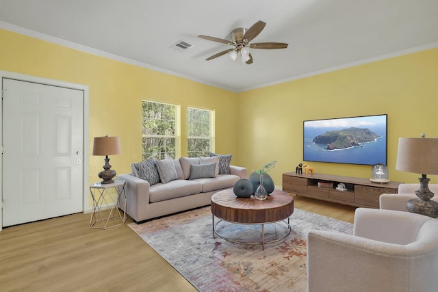 living room with light wood-type flooring, ceiling fan, and crown molding