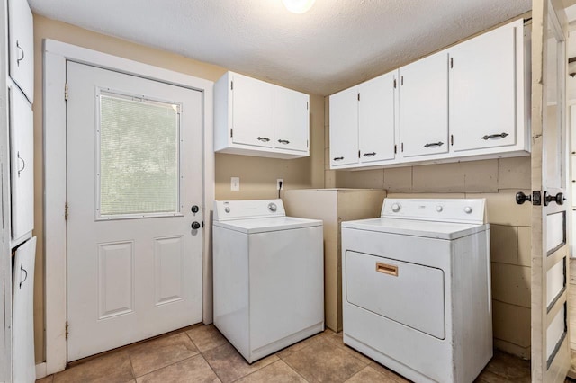 450 W Dogwood St, Monticello, FL 32344 - laundry area featuring a textured ceiling, light tile patterned floors, washing machine and dryer, and cabinet space