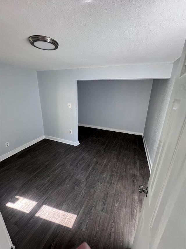 interior space featuring a textured ceiling and dark hardwood / wood-style floors