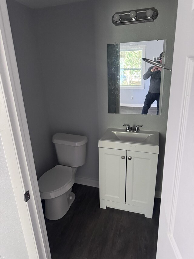 bathroom with hardwood / wood-style flooring, vanity, and toilet