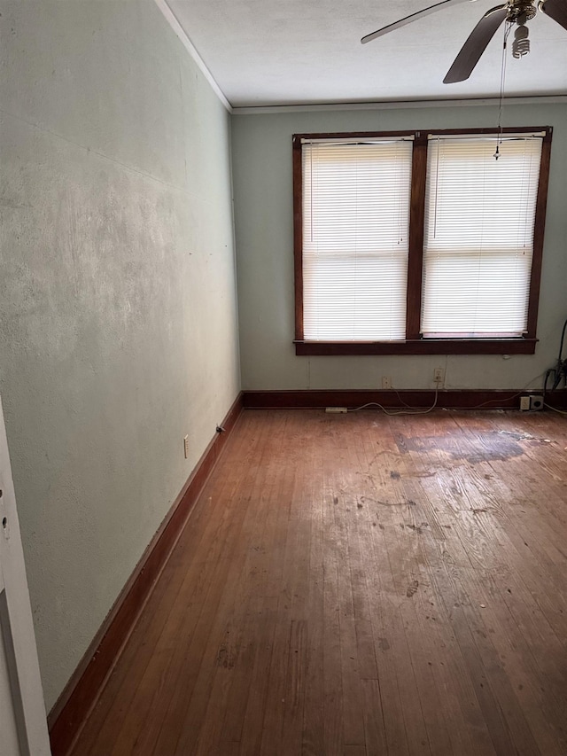 unfurnished room featuring hardwood / wood-style floors, a wealth of natural light, ceiling fan, and ornamental molding