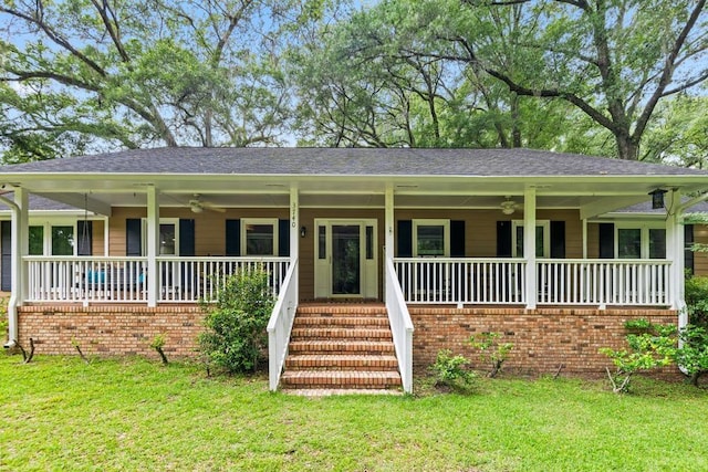 view of front facade with ceiling fan, a porch, and a front lawn