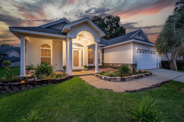 view of front of property featuring a garage and a yard