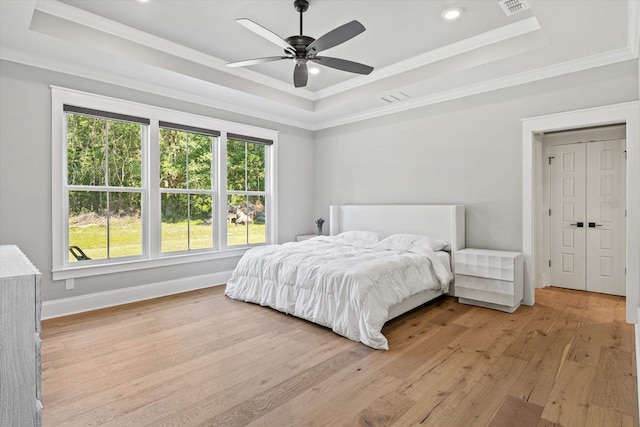1020 Baum Rd, Tallahassee, FL 32317 - bedroom with a tray ceiling, multiple windows, light wood-style floors, ornamental molding, and recessed lighting