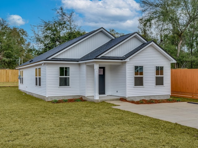 57 Mohawk Trl, Crawfordville, FL 32327 - view of front of property with a patio, a front lawn, a shingled roof, and fence