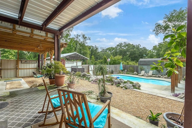 view of patio / terrace featuring a fenced in pool and a storage shed