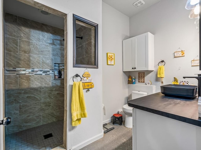 bathroom with vanity, toilet, and a tile shower