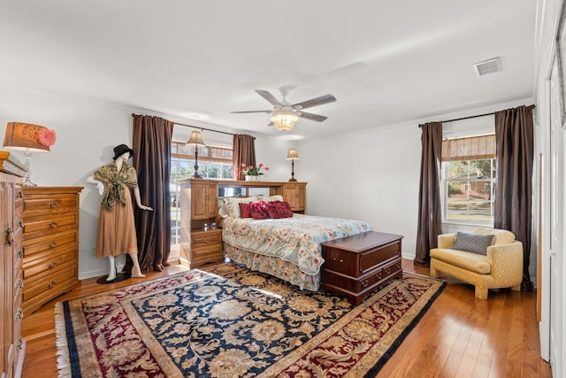 bedroom with multiple windows, crown molding, light hardwood / wood-style flooring, and ceiling fan