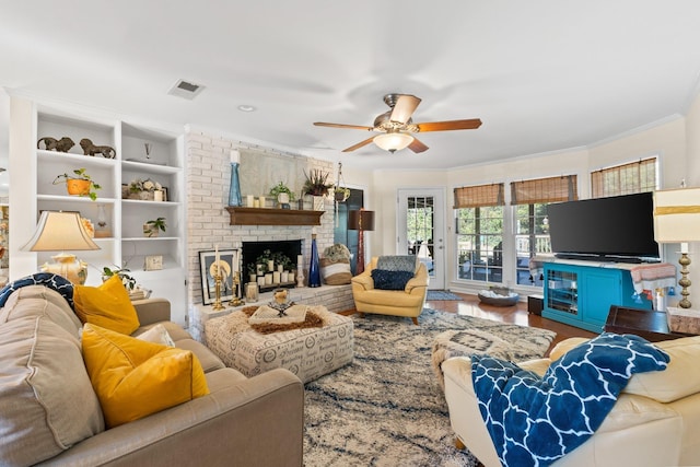 living room featuring crown molding, a brick fireplace, hardwood / wood-style flooring, and ceiling fan