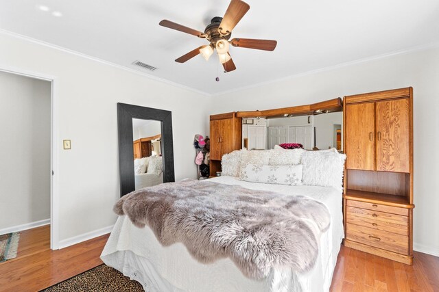 bedroom featuring ornamental molding, light hardwood / wood-style floors, and ceiling fan