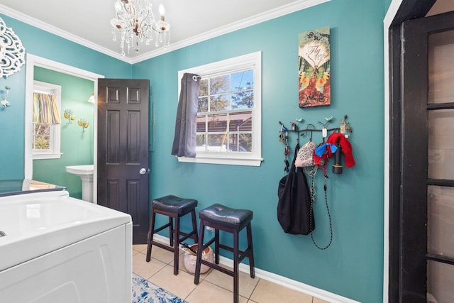 washroom with crown molding, separate washer and dryer, a chandelier, and light tile patterned floors